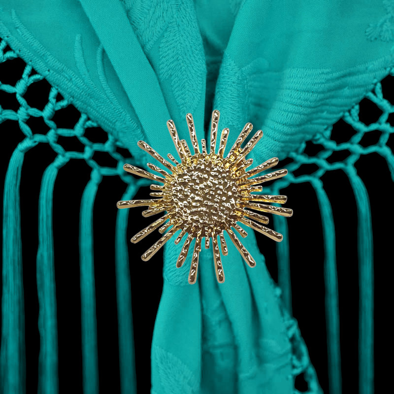 太陽の形をした金色のブローチ